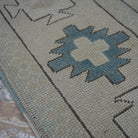 Beige 7' x 10' vintage Turkish wool rug in wool, shown on the floor.