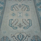 Close-up of the pale blue vintage Turkish wool rug showing geometric details, hand-knotted weave, wool and low pile.