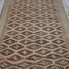 Close-up of the pale orange vintage Turkish wool rug showing neutral details, hand-knotted weave, wool and low pile.