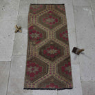 Brown 2' x 4' Turkish wool kilim rug in wool and cotton, shown on the floor.