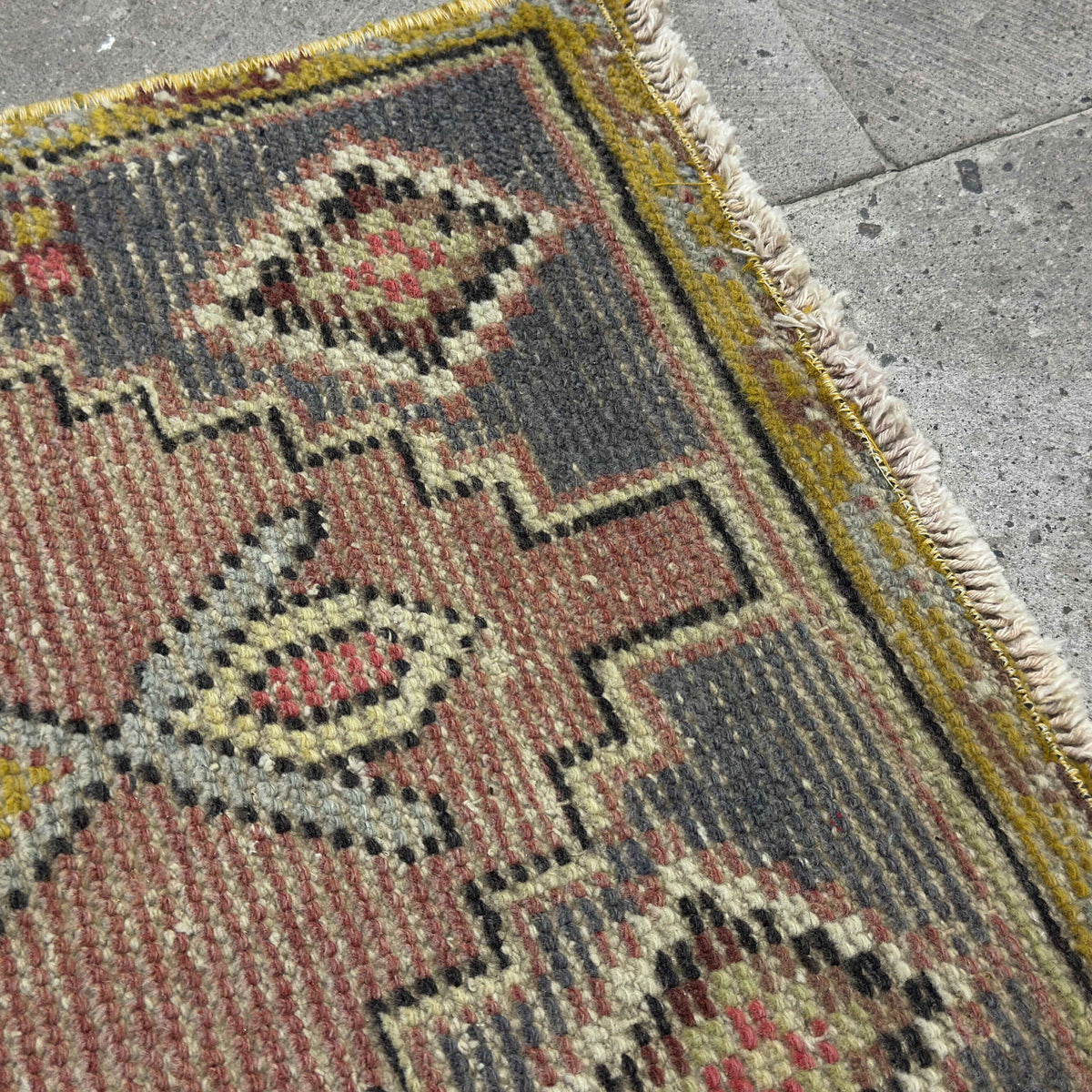 Close-up of the yellow Turkish wool traditonal rug showing traditional details, hand-knotted weave, wool and cotton and low pile.