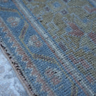 Blue 6' x 11' wool turkish rug in wool, shown on the floor.