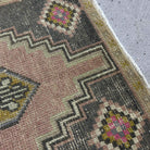 Close-up of the pale pink Turkish wool vintage rug showing traditional details, hand-knotted weave, wool and cotton and low pile.