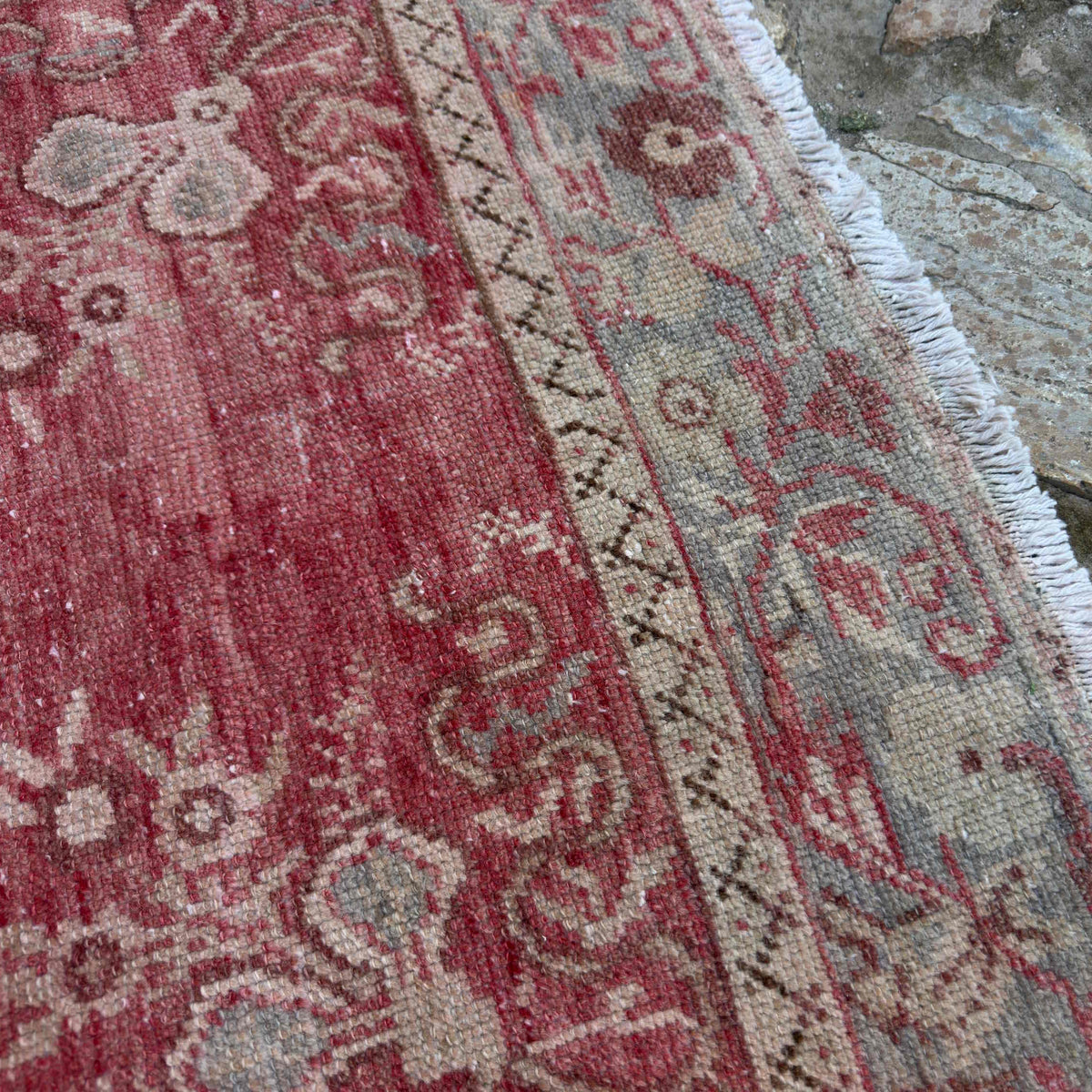 Close-up of the red Turkish wool vintage rug showing traditional details, hand-knotted weave, wool and cotton and low pile.